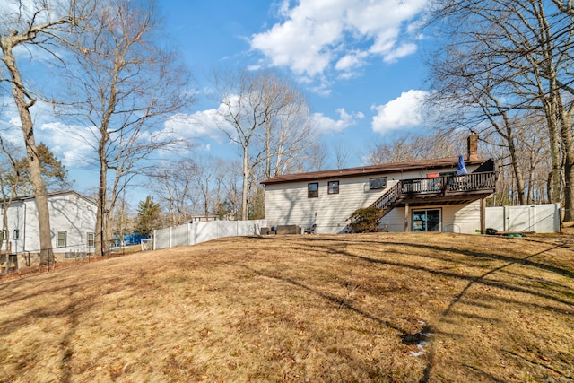 back of house with a wooden deck and a yard