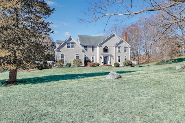 view of front facade with a front lawn and a chimney