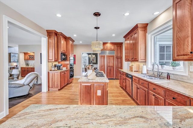 kitchen featuring a sink, a center island, light wood-style floors, black microwave, and a chandelier