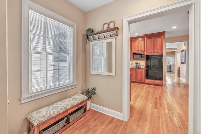 corridor with recessed lighting, light wood-style flooring, and baseboards