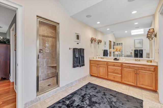 full bathroom featuring double vanity, recessed lighting, a stall shower, and a sink