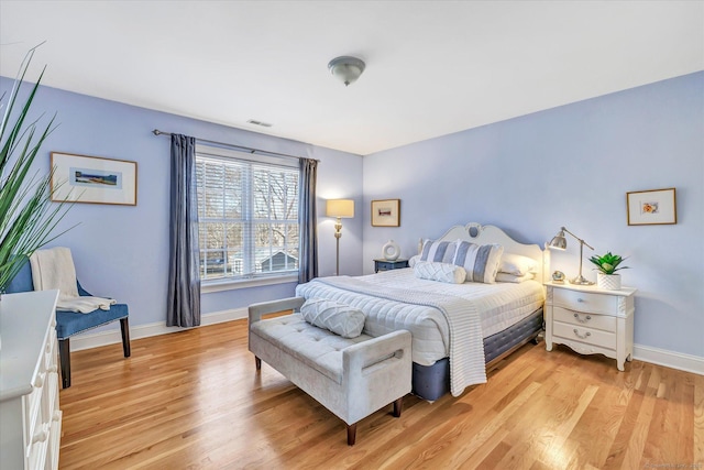 bedroom with visible vents, light wood-style flooring, and baseboards