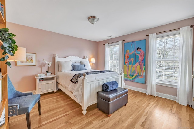 bedroom featuring visible vents, baseboards, and light wood-style flooring