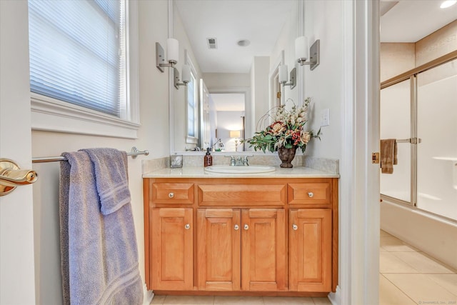 full bathroom featuring combined bath / shower with glass door, visible vents, vanity, and tile patterned flooring