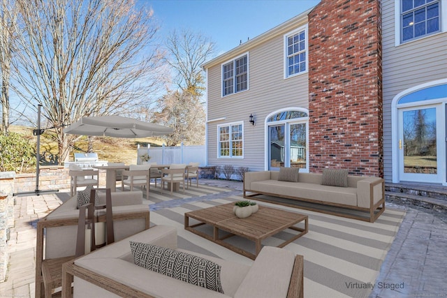 view of patio with area for grilling, outdoor lounge area, outdoor dining area, and fence