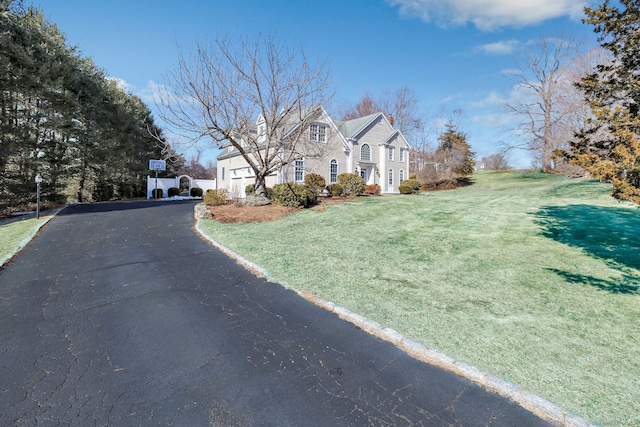 exterior space with aphalt driveway and a lawn