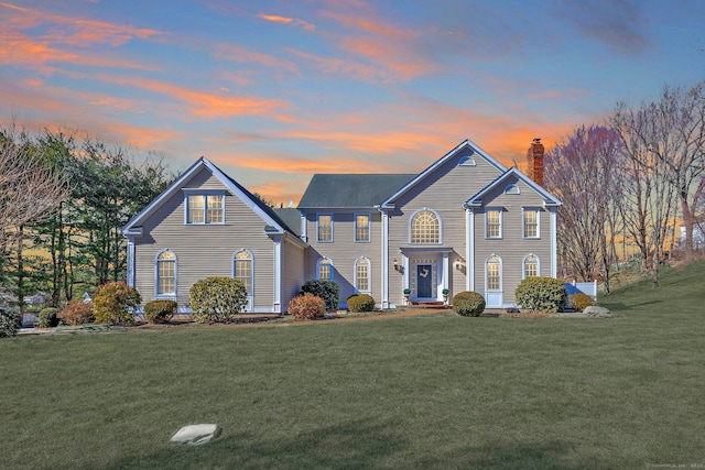 view of front of house with a lawn and a chimney