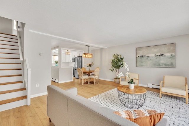 living room with a baseboard heating unit and light hardwood / wood-style floors