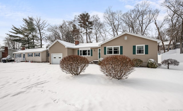 snow covered house with a garage