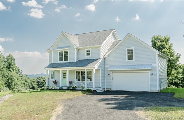 view of front facade with a garage, a front lawn, and a porch