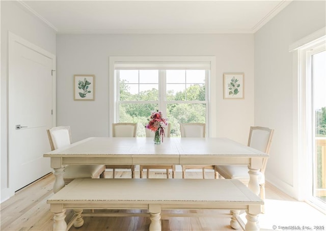 dining space featuring ornamental molding and light wood-type flooring