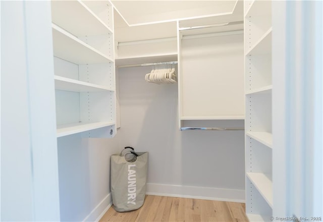 walk in closet with hardwood / wood-style floors