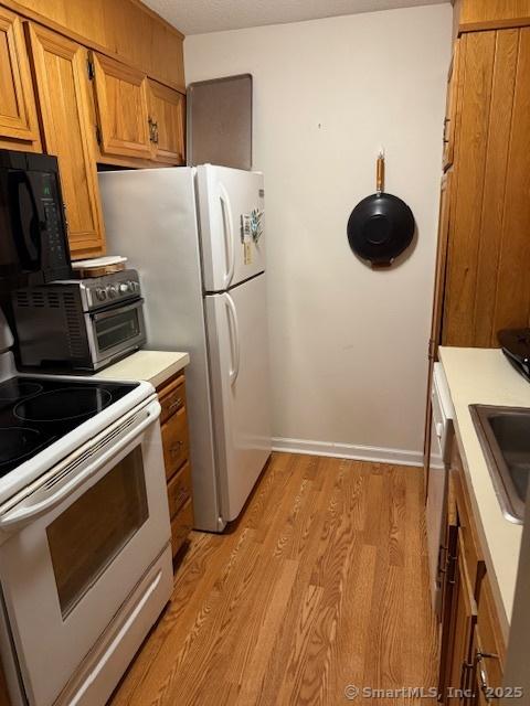 kitchen featuring sink, electric range, and light hardwood / wood-style flooring