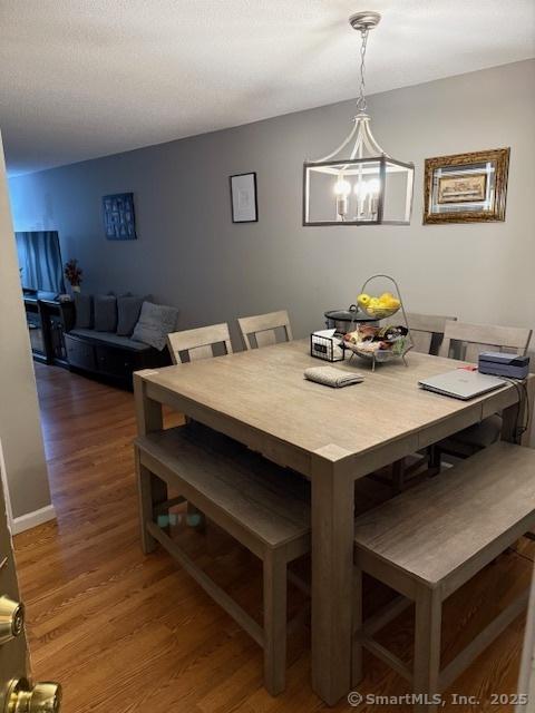 dining room with an inviting chandelier and dark hardwood / wood-style flooring