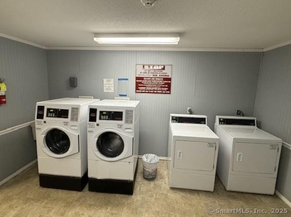 laundry area with ornamental molding and washing machine and dryer