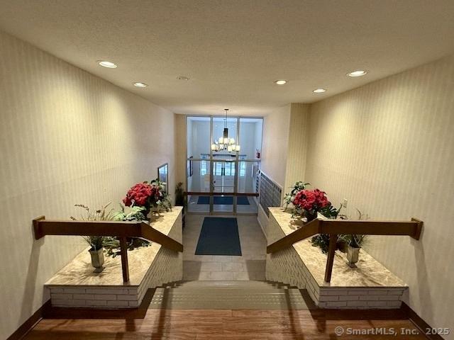 hallway featuring hardwood / wood-style floors and a notable chandelier