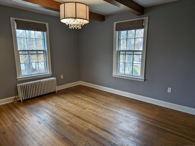 unfurnished room featuring hardwood / wood-style floors, a healthy amount of sunlight, radiator heating unit, and beam ceiling