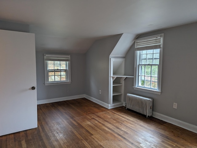 bonus room featuring vaulted ceiling, radiator, and dark hardwood / wood-style floors