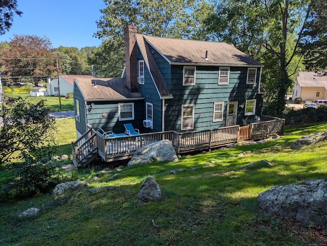 rear view of house with a wooden deck and a lawn