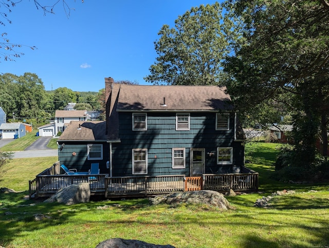 rear view of house featuring a wooden deck and a lawn