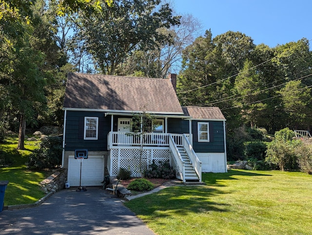 view of front of home featuring a garage, a front yard, and covered porch