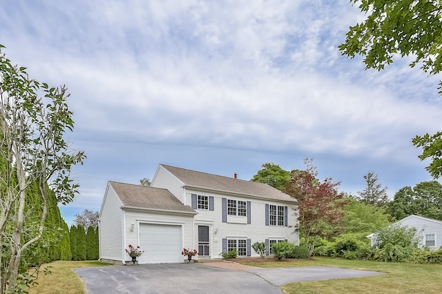 colonial inspired home with a garage and a front yard