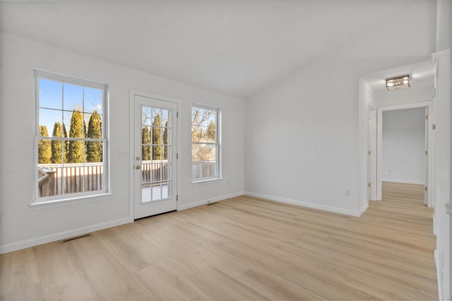 spare room featuring vaulted ceiling and light hardwood / wood-style flooring