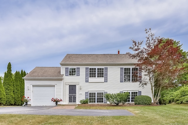 view of front of property with a garage and a front lawn