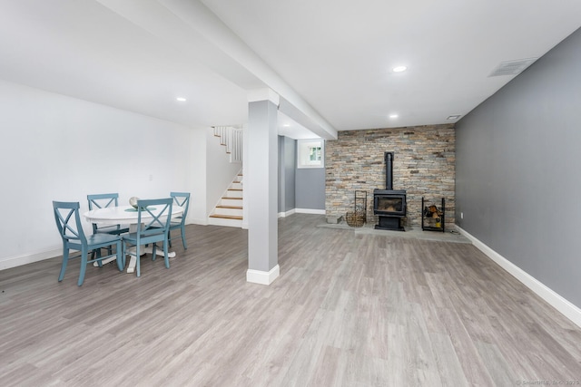 unfurnished living room with light hardwood / wood-style flooring and a wood stove