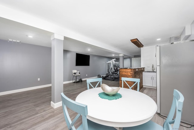 dining space with hardwood / wood-style flooring and sink