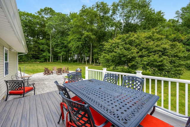 wooden terrace with a lawn and an outdoor fire pit