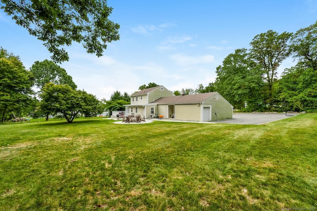 view of yard with a garage and a patio area