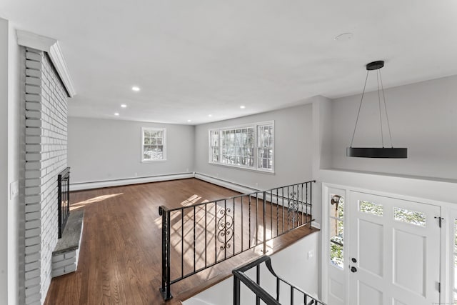 foyer with a baseboard radiator, dark hardwood / wood-style floors, and a fireplace