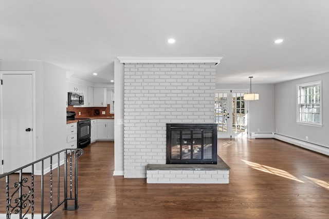 living room featuring a brick fireplace and dark wood-type flooring