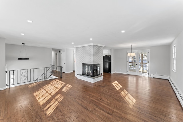 unfurnished living room with a fireplace, dark hardwood / wood-style flooring, and baseboard heating