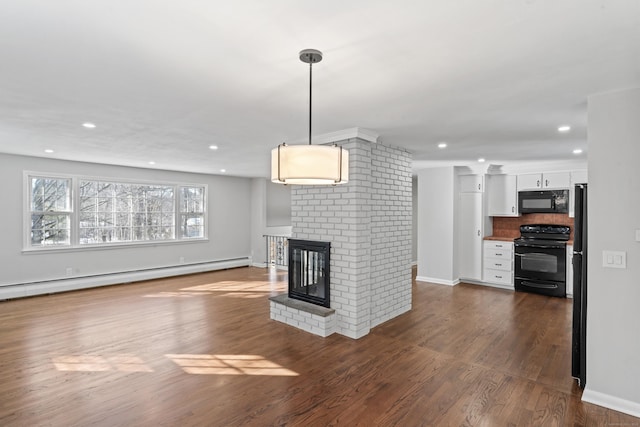 unfurnished living room with baseboard heating, dark hardwood / wood-style floors, and a fireplace