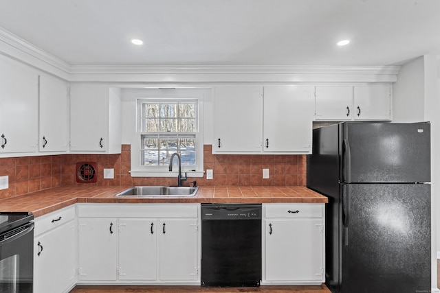 kitchen featuring sink, tile countertops, black appliances, and white cabinets