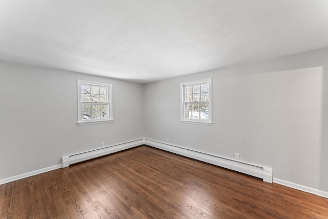 spare room with wood-type flooring, plenty of natural light, and baseboard heating