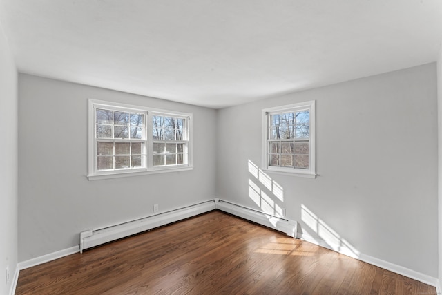 unfurnished room with hardwood / wood-style flooring, a healthy amount of sunlight, and baseboard heating