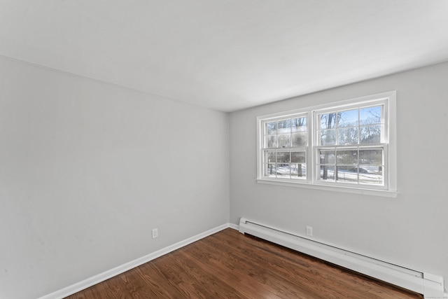 empty room featuring hardwood / wood-style flooring and a baseboard radiator