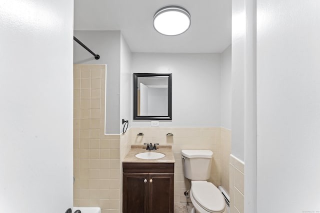 bathroom with vanity, toilet, and tile walls