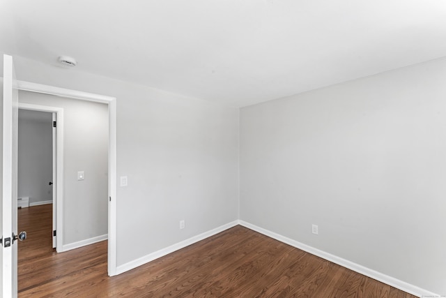 spare room featuring wood-type flooring and a baseboard radiator