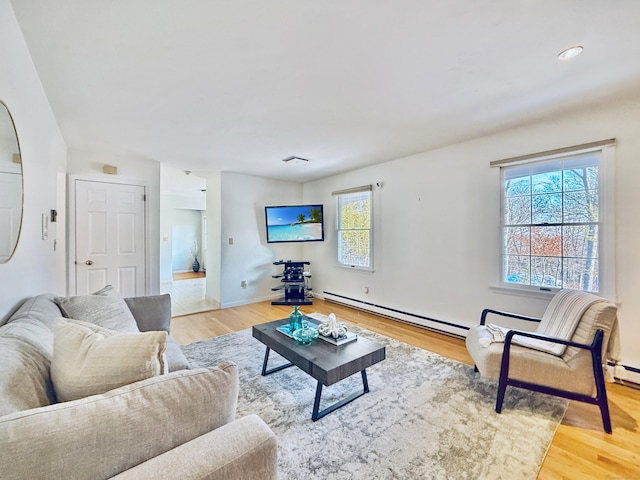 living room featuring a baseboard heating unit and light hardwood / wood-style flooring