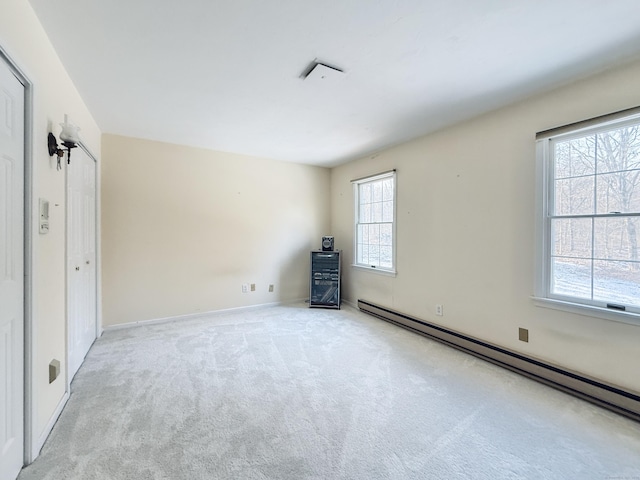 unfurnished bedroom with baseboard heating and light carpet