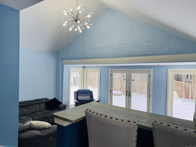 living room with french doors, lofted ceiling, and a chandelier