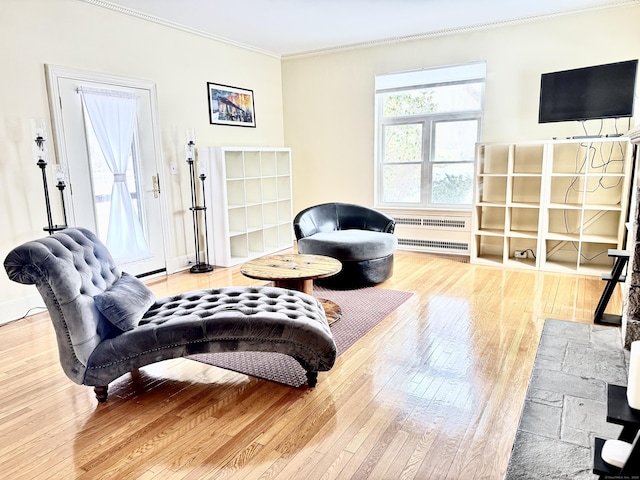 living room with hardwood / wood-style flooring, crown molding, and radiator heating unit