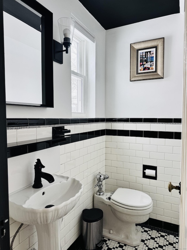 bathroom featuring sink, tile walls, tile patterned floors, and toilet