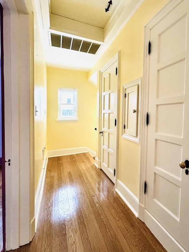 corridor with hardwood / wood-style flooring