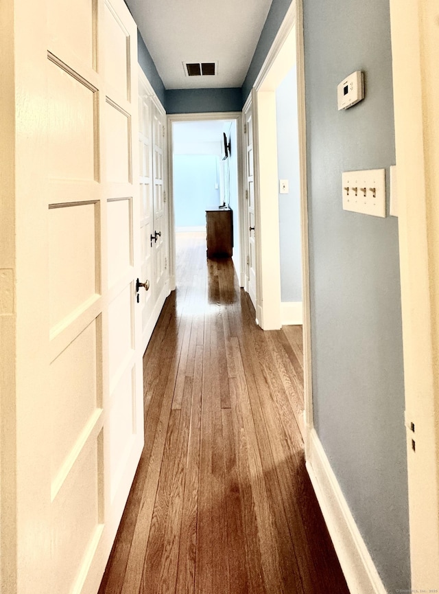 corridor with hardwood / wood-style floors