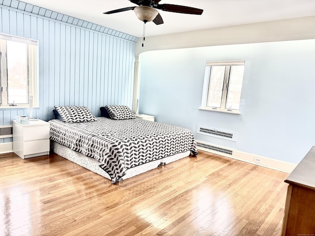 bedroom with multiple windows, ceiling fan, and light hardwood / wood-style flooring